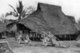 Thailand: Ox carts lie in front of a traditional thatched wooden house on stilts in rural Phitsanulok, central Thailand, c. 1900.