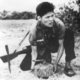 Vietnam: An NLF guerrilla posing laying a land mine for a propaganda photograph, c.1966.